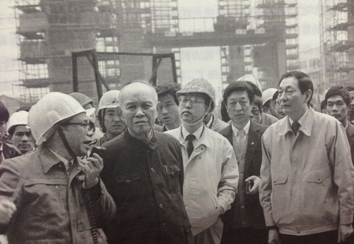 1990年3月30日，朱�F基陪同中共中央政治局常委、国务院副总理姚依林考察正在建设中的上海南浦大桥浦东工地。