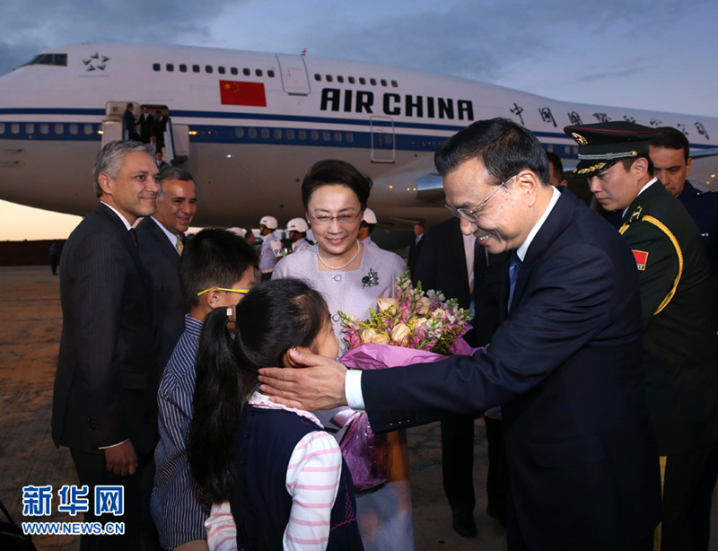 5月18日，應巴西聯邦共和國總統羅塞夫邀請，中國國務院總理李克強乘專機抵達巴西利亞空軍基地，開始對巴西進行正式訪問。李克強總理夫人程虹同機抵達。這是少年向李克強和夫人程虹獻上鮮花。 新華社記者 龐興雷 攝