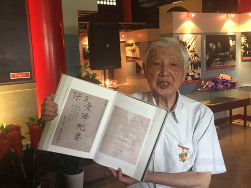 抗戰老兵王楚英對照歷史檔案回憶當年日軍投降場景。 姚雪青 攝