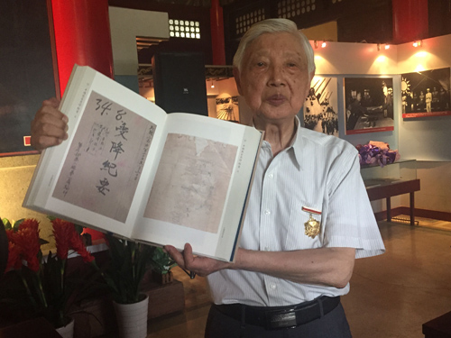 抗戰老兵王楚英對照歷史檔案回憶當年日軍投降場景。 姚雪青 攝