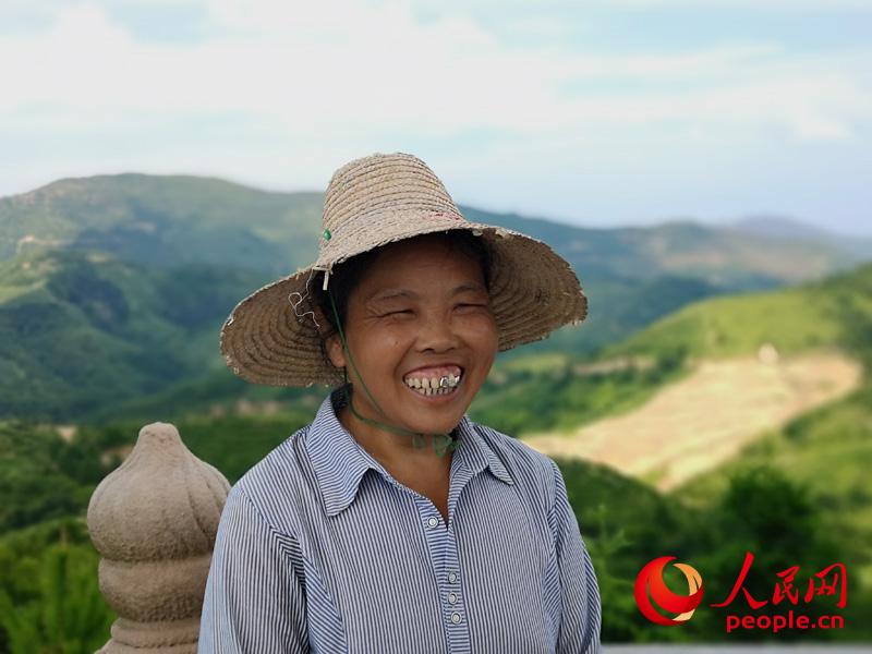 “以前山上全是光禿禿的，現在變成綠油油的茶園，我們高興啊。” 於都縣段屋鄉勝利村村民伍小平開心地告訴記者。（攝影：鄧志慧）