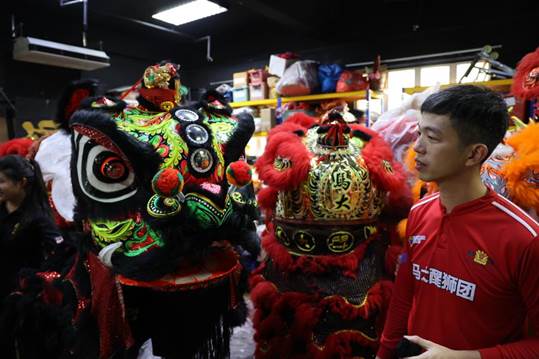 马大醒狮团仓库，刘佳峰向记者介绍狮头含义。 本报记者 宦翔 摄