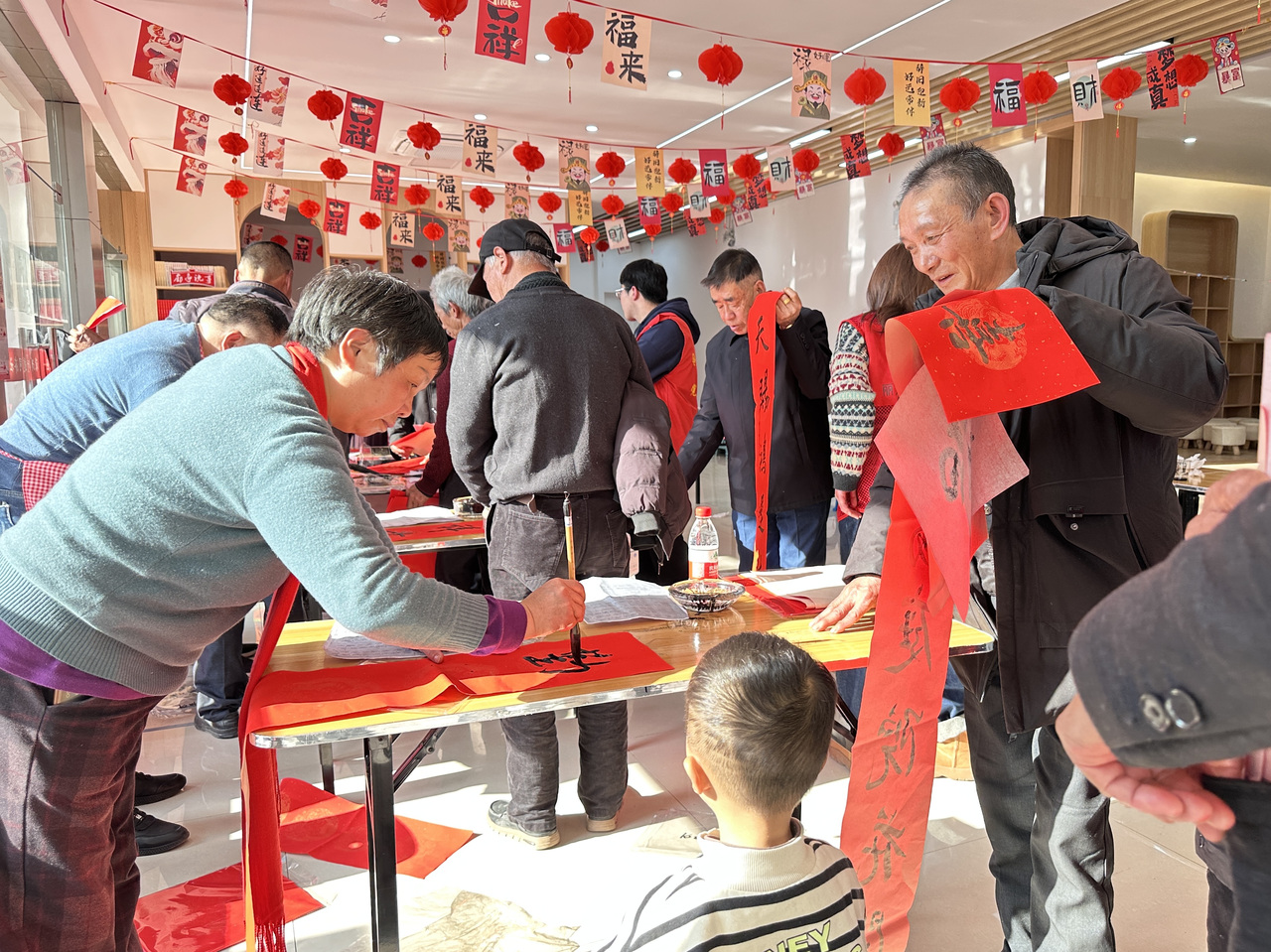 今年春节前夕，庆元县濛洲街道同济新村，一场送春联活动热闹举行。庆元县融媒体中心 供图