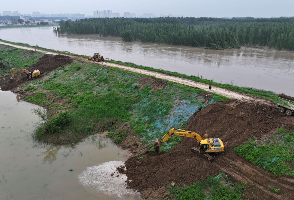 工人操作機械在白溝河左堤白溝新城高橋村段進行除險加固作業（8月4日攝，無人機照片）。新華社記者 朱旭東 攝