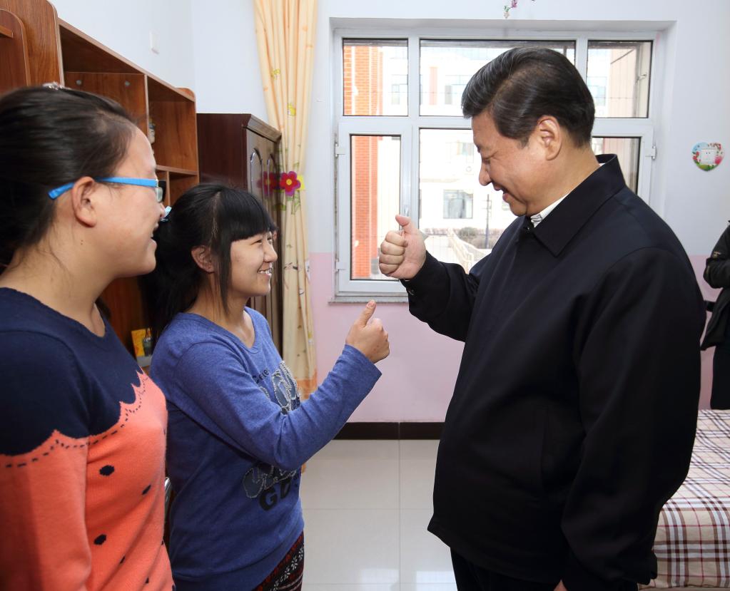 2014年1月28日，習近平總書記在呼和浩特市兒童福利院宿舍向聾啞女孩學習啞語“謝謝”。新華社記者 蘭紅光 攝
