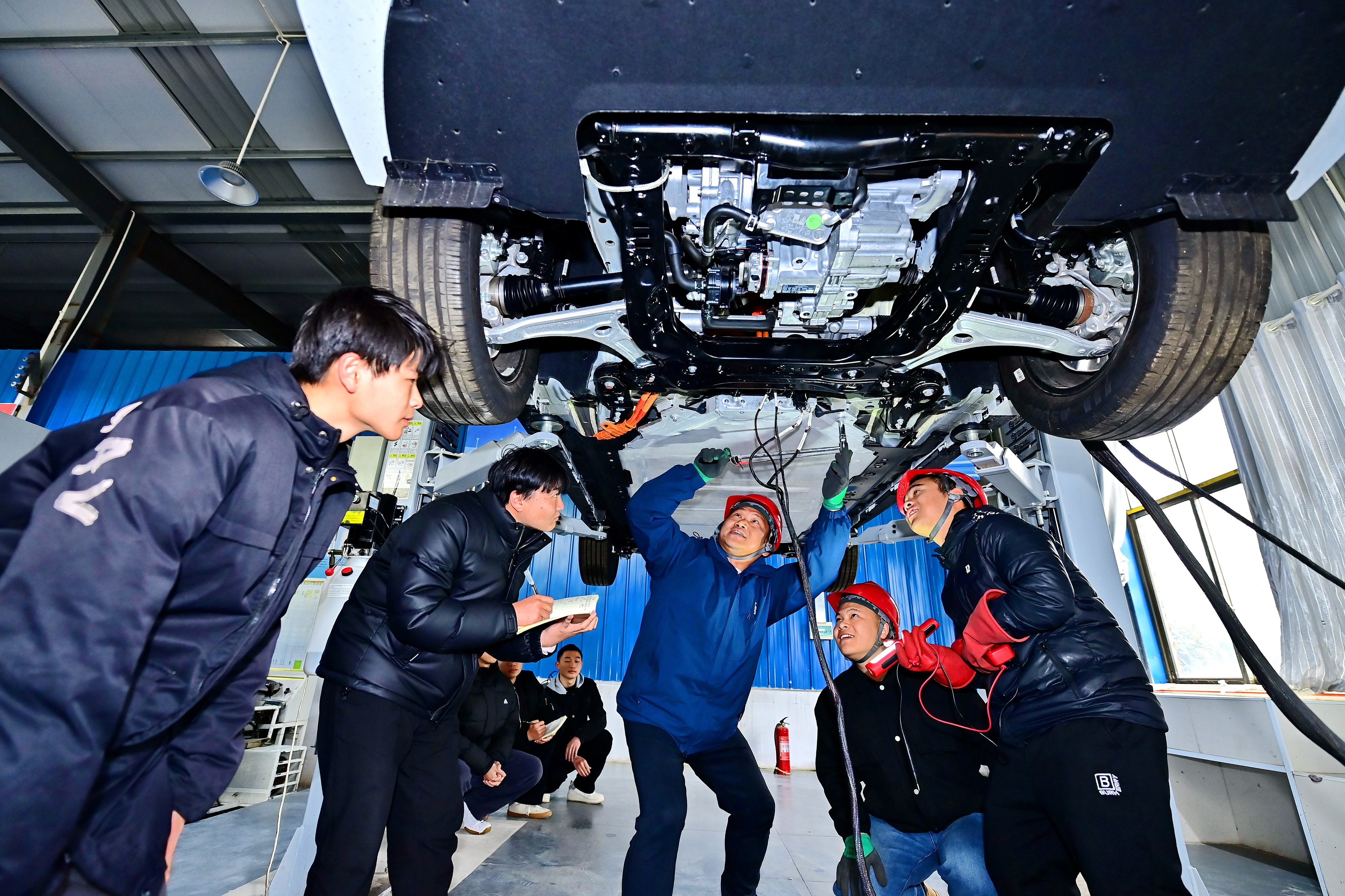 2025年2月，江西省宜春市，豐城市的一所技工學校實訓基地內，新能源汽車運維專業學生在老師的指導下學習新能源汽車電池包檢修技術。