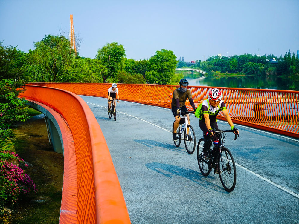 2023年6月25日,市民在四川成都锦城湖公园绿道上骑行。