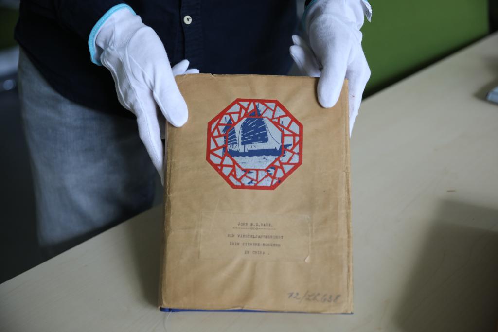 7月30日，在德国柏林的西门子历史档案馆，历史学家埃瓦尔德·布勒歇尔展示《拉贝日记》部分原件。新华社记者 杜哲宇 摄