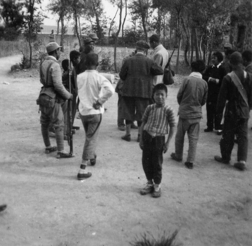 贝熙业（中间背影）与八路军战士及村民在一起。（中共北京市海淀区委宣传部供图）