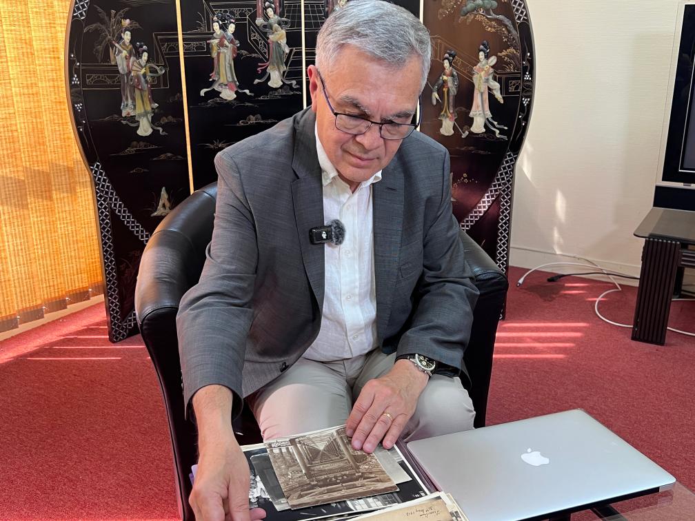 2025年6月23日，贝石涛在巴黎近郊接受记者采访时翻看与贝熙业医生相关的历史资料。新华社记者 孙鑫晶 摄