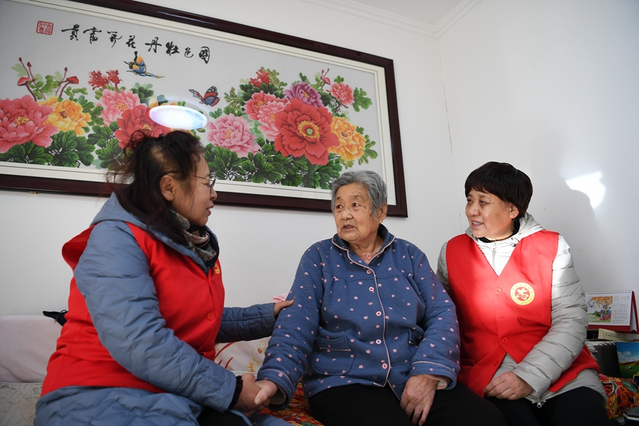 河北省承德市滨河社区志愿者到独居老人张郁馥家中走访(2021年12月16日摄)。新华社记者 朱旭东 摄