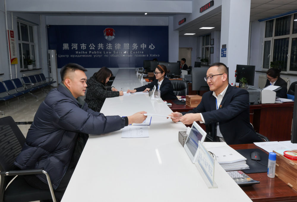 2024年12月10日,黑龙江省黑河市公共法律服务中心的工作人员在为涉外企业办理业务。新华社记者 殷刚 摄